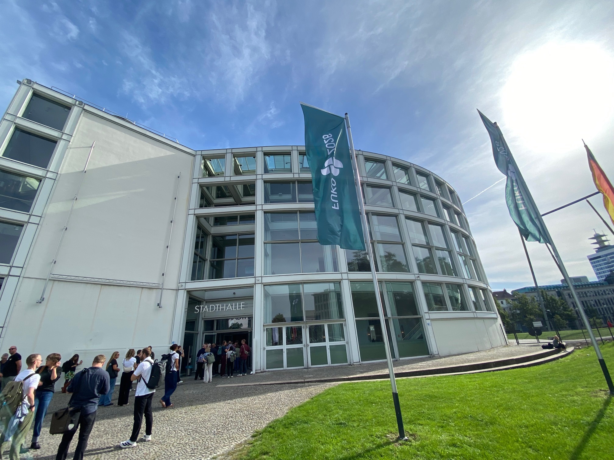 Auf dem Foto ist der Eingang der Stadthalle Bielefeld zu sehen, mit der Ankündigung des FUKO über eine der wehenden Fahnen am Eingang