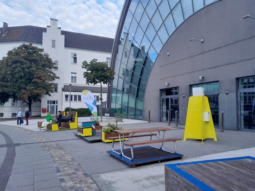Auf dem Bild sind verschiedene Stadtmöbel zu sehen, die auf Straßen, Gehwegen usw. mobil platziert werden können und zusätzliche Sitzplätze in der Öffentlichkeit bieten