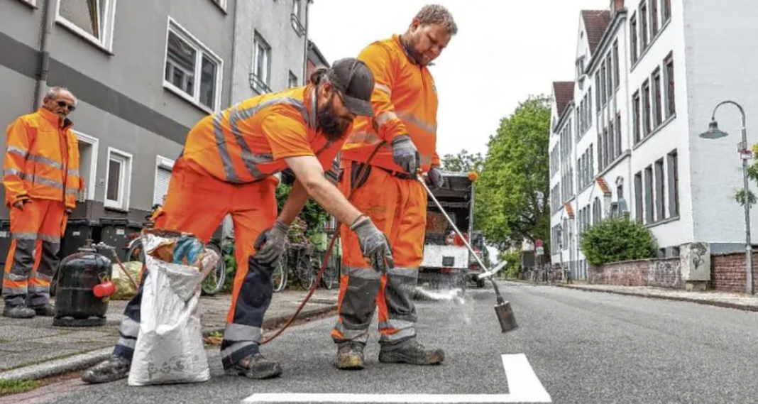 Zwei Bauarbeiter bringen im Auftrag des ASV Markierungen für das Bewohnerparken in der Oderstr. in Bremen an