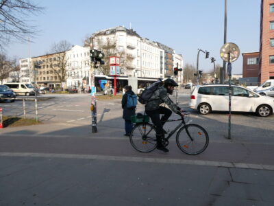 Radler auf Radweg zwischen Gehweg und Ampelwarteplatz