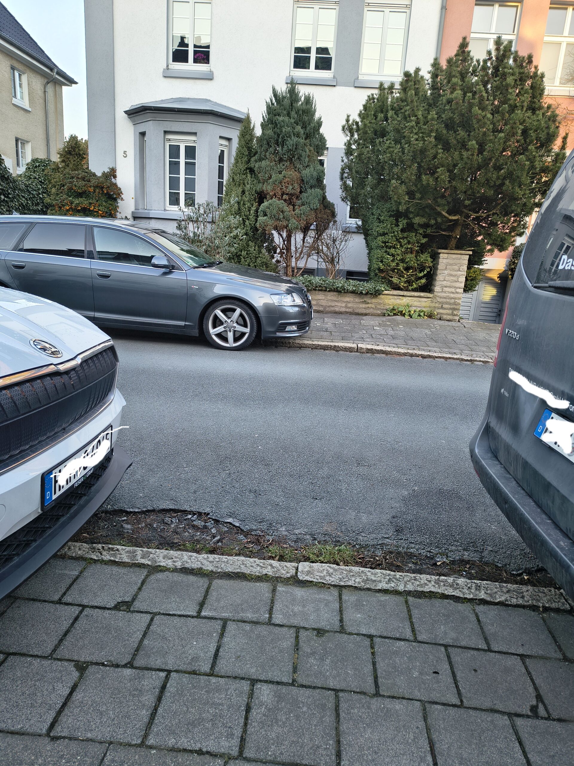 Kindersicht auf den Schulweg, parkende Autos blockieren die Sicht auf den Verkehr.