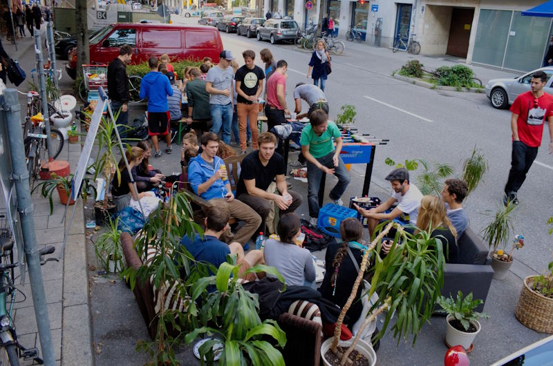 Menschen sitzen in einer Parkbucht
