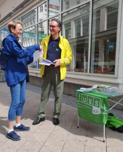 Flugblatt wird an Passantin verteilt