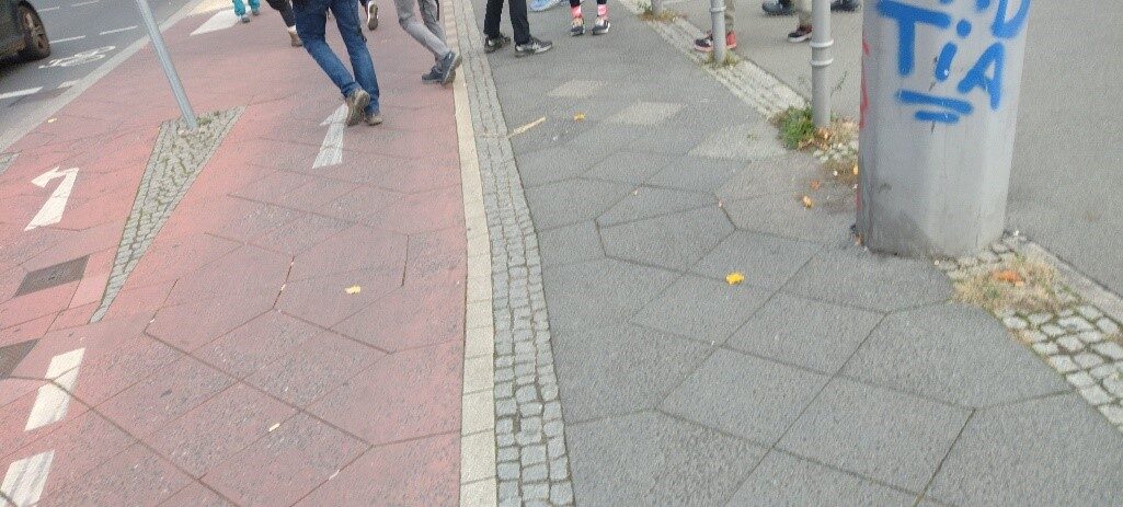 Fußgänger überqueren Radweg