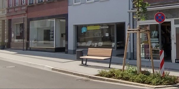 Renovierter Gehsteig mit einer neuen Bank, neben der ein Baum gepflanz wurde.