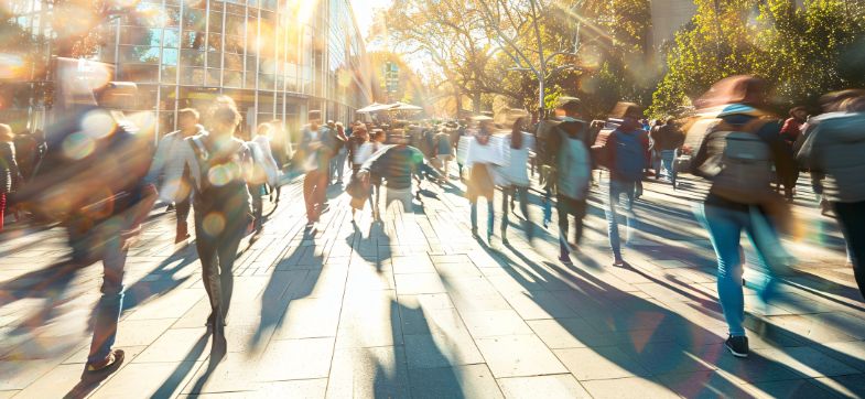 viele Menschen in einer Fußgängerzone bei Sonnenschein