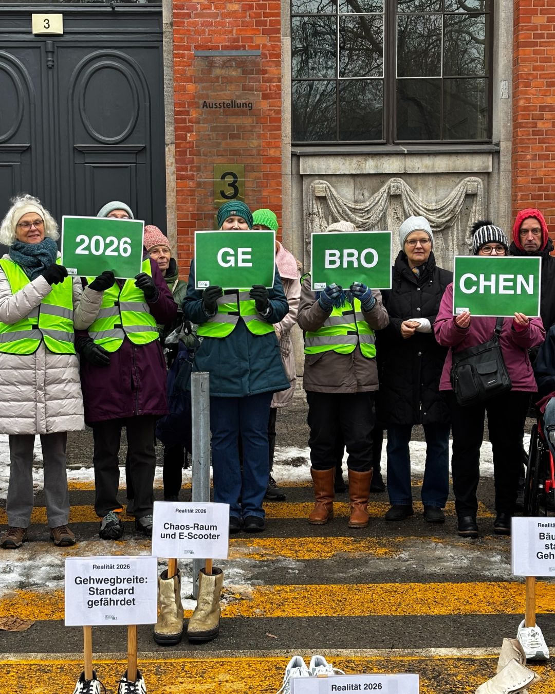 Aktivist:innen von FUSS e.V. halten Schilder hoch mit der Aufschrift: 2026 gebrochen