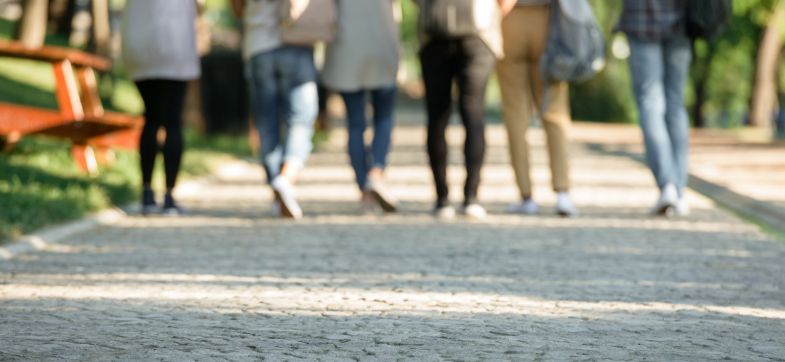 Eine Gruppe Menschen zu Fuß läuft durch einen Park